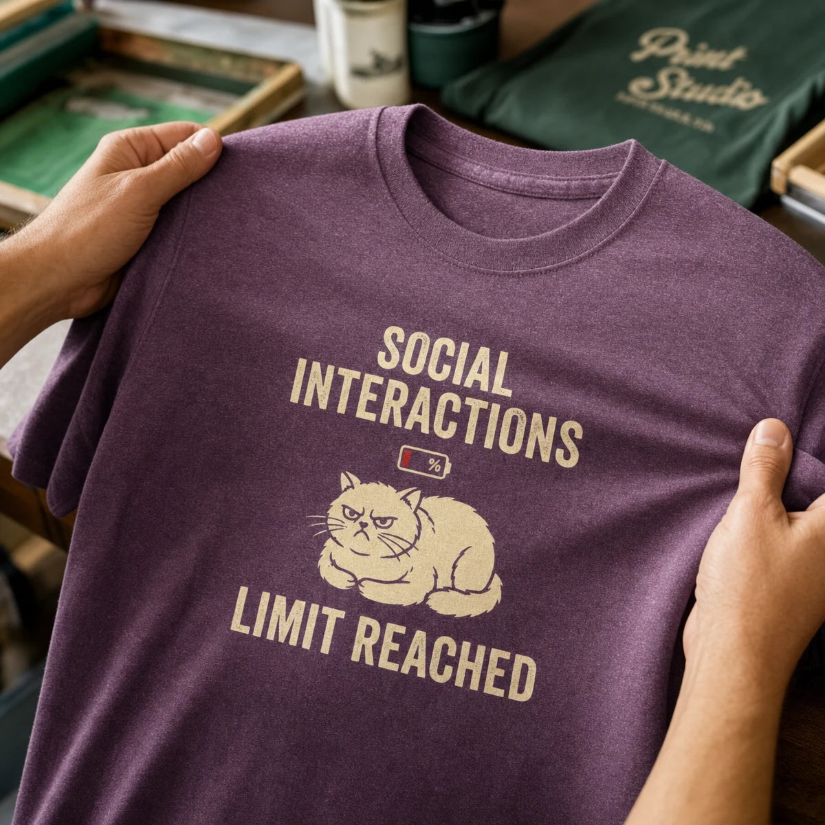 Hands inspecting a printed Social Interactions Limit Reached T-shirt
